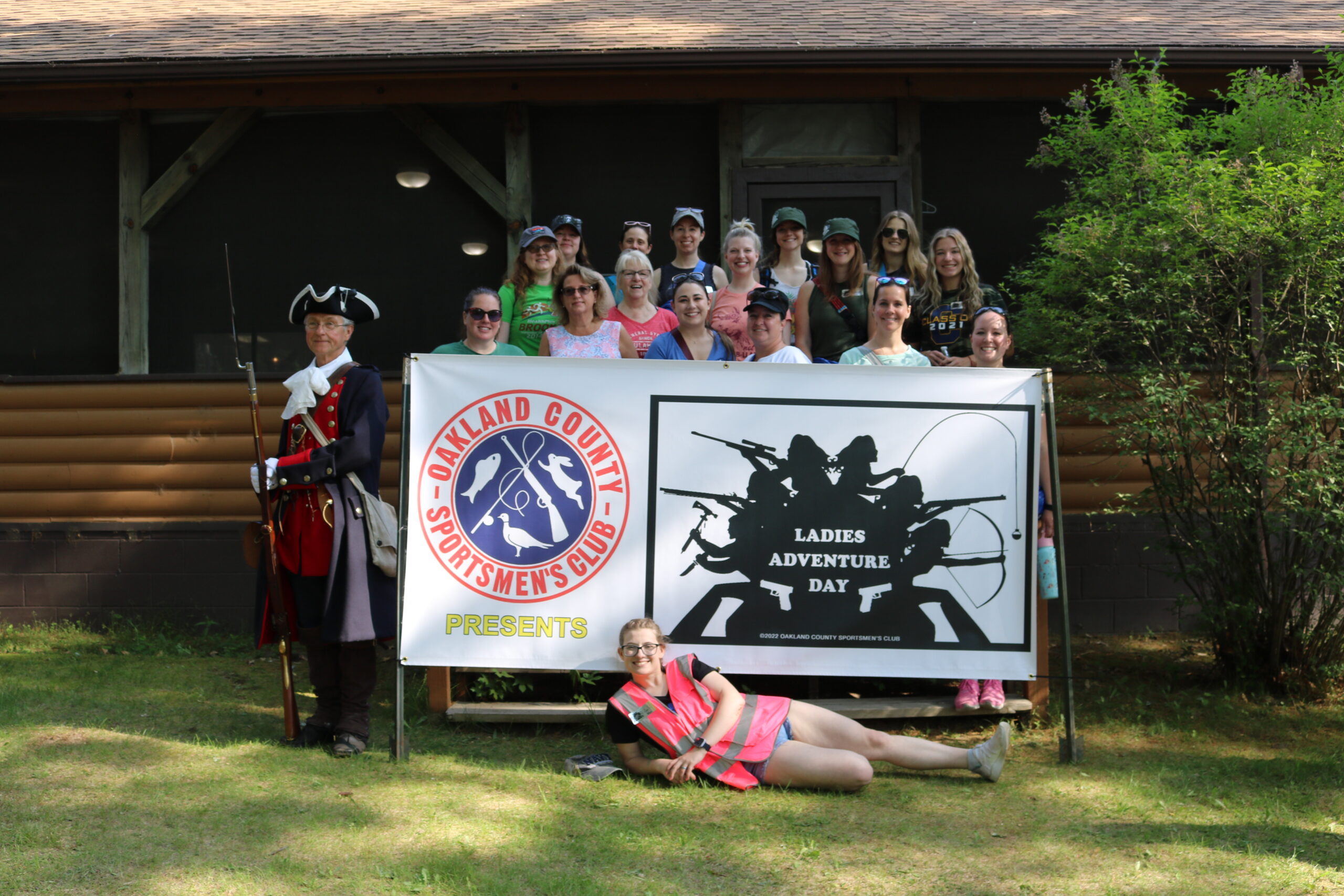 Participants and volunteers pose with the Ladies Adventure Day Banner.